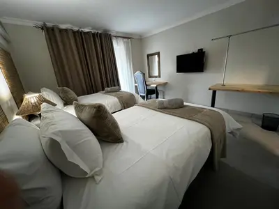 a hotel room with two beds and a television at Moya-Sky in Komatipoort