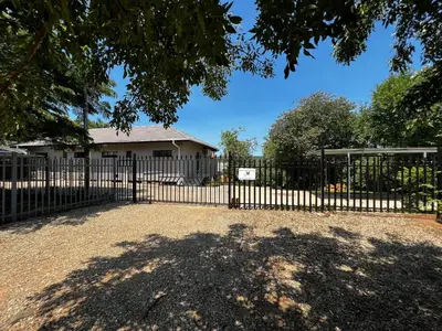 a black fence with a gate in front of a house at Moya-Sky in Komatipoort