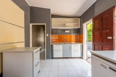 a kitchen with white appliances and an open door at House Firefly Muckleneuk - Furnished House in Pretoria