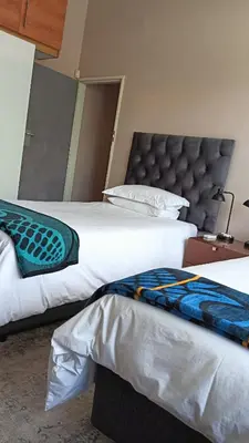 two beds sitting next to each other in a bedroom at House Firefly Muckleneuk - Furnished House in Pretoria