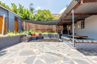 an outdoor patio with a table and benches at House Firefly Muckleneuk - Furnished House in Pretoria