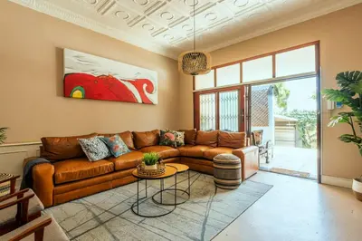 a living room with a brown couch and a table at House Firefly Muckleneuk - Furnished House in Pretoria