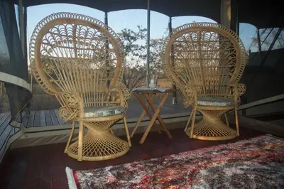 two wicker chairs and a table on a porch at Out in Africa Wildlife Lodge in Dinokeng Game Reserve