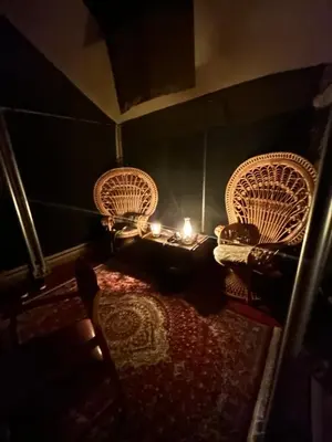 a room with two chairs and a table with a candle at Out in Africa Wildlife Lodge in Dinokeng Game Reserve