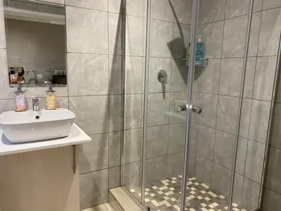 a bathroom with a shower and a sink at The Manor in Midrand