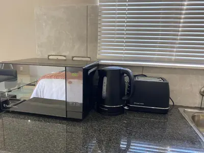 a coffee maker and a microwave on a counter at The Manor in Midrand