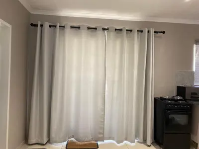 a white curtain in a room with a window at The Manor in Midrand