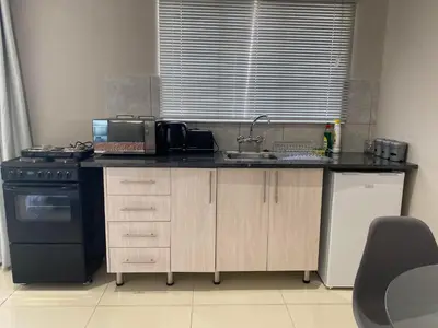 a kitchen with a sink and a stove at The Manor in Midrand