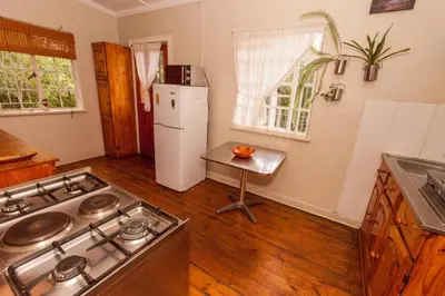 a kitchen with a stove and a white refrigerator at Climber's house in Waterval Boven