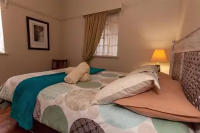 a bedroom with a large bed with pillows at Climber's house in Waterval Boven