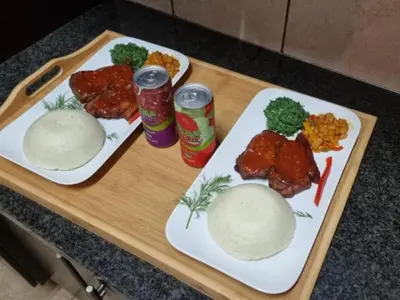 two plates of food with meat and vegetables on a table at Tee Cee Marvelous Guesthouse in Thabazimbi