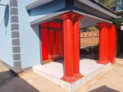a building with red columns and a red door at Tee Cee Marvelous Guesthouse in Thabazimbi