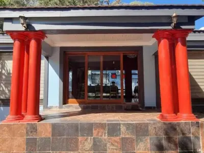 two red columns in front of a building at Tee Cee Marvelous Guesthouse in Thabazimbi
