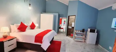a bedroom with a large bed with red pillows at Tee Cee Marvelous Guesthouse in Thabazimbi