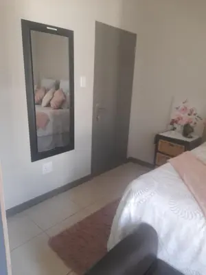 a bedroom with a bed and a mirror on the wall at Neat Appartment, Fourways in Midrand