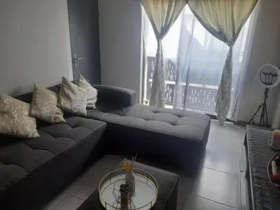 a living room with a couch and a large window at Neat Appartment, Fourways in Midrand