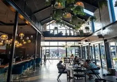 a restaurant with people sitting at tables in a room at Neat Appartment, Fourways in Midrand