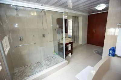 a bathroom with a shower and a sink at Zoe BnB in Midrand