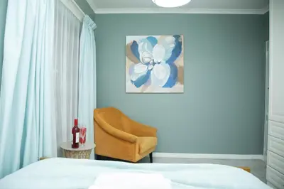 a bedroom with a bed and a yellow chair at Origon Farmhouse in Brits