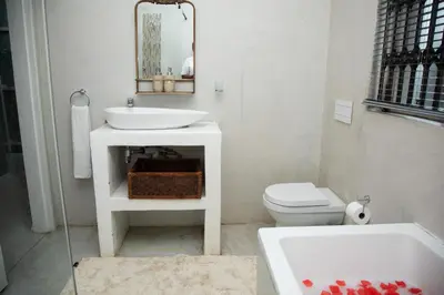 a white bathroom with a sink and a toilet at Origon Farmhouse in Brits