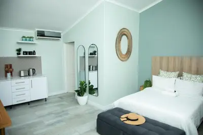 a bedroom with a bed and a stool with a hat on it at Origon Farmhouse in Brits