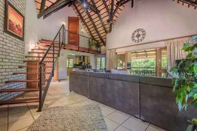 a living room with a staircase and a couch at Kruger Park Lodge Unit No. 241 in Hazyview