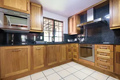 a kitchen with wooden cabinets and black counter tops at Kruger Park Lodge Unit No. 241 in Hazyview