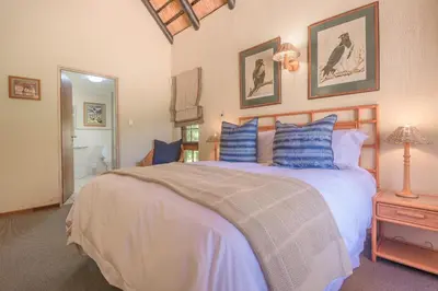 a bedroom with a large bed with blue pillows at Kruger Park Lodge Unit No. 241 in Hazyview