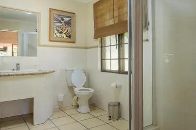 a bathroom with a toilet and a sink and a shower at Kruger Park Lodge Unit No. 241 in Hazyview