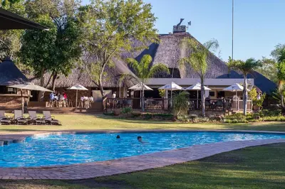 a pool at a resort with people swimming in it at Kruger Park Lodge Unit No. 241 in Hazyview