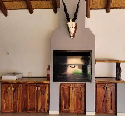 a living room with a tv and a cow head on the wall at Makhato Bush Lodge 48 in Bela-Bela
