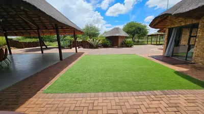 a yard of green grass next to a building at Makhato Bush Lodge 48 in Bela-Bela