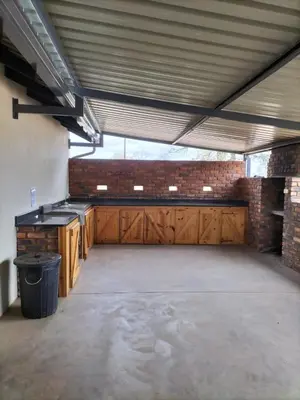 an empty garage with wooden cabinets and a brick wall at Mukumbura Swartwater in Swartwater
