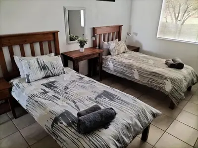 a bedroom with two beds and a mirror at Mukumbura Swartwater in Swartwater