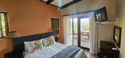 a bedroom with a bed with a television on the wall at Robin Cottage Da Gama Lake in White River