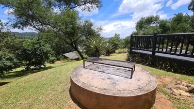 a bench sitting on top of a large tree stump at Robin Cottage Da Gama Lake in White River