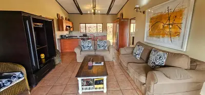 a living room with two couches and a coffee table at Robin Cottage Da Gama Lake in White River