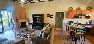 a kitchen and living room with a couch and a table at Robin Cottage Da Gama Lake in White River