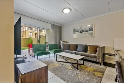 a living room with a couch and chairs at Modern 3-bed Garden Apartment in Waterfall in Midrand