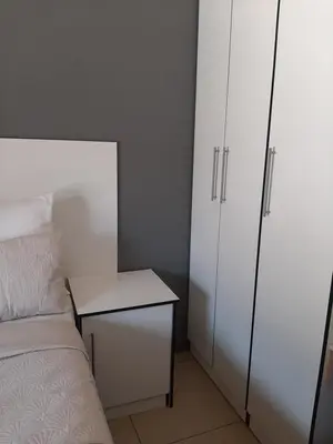 a bedroom with a bed and a white cabinet at Fumas guesthouse in Duvhapark