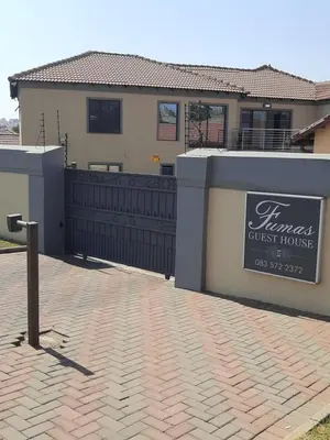 a house with a sign in front of a brick driveway at Fumas guesthouse in Duvhapark