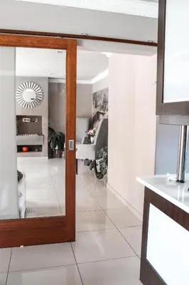 a kitchen with a mirror and a living room at Modern Home in Pretoria near Menlyn Mall in Pretoria
