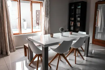 a white table and chairs in a room with a window at Modern Home in Pretoria near Menlyn Mall in Pretoria