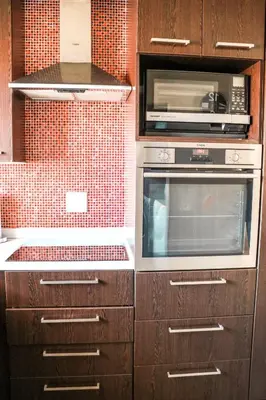 a kitchen with wooden cabinets and a microwave at Modern Home in Pretoria near Menlyn Mall in Pretoria