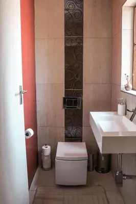 a bathroom with a toilet and a sink at Modern Home in Pretoria near Menlyn Mall in Pretoria