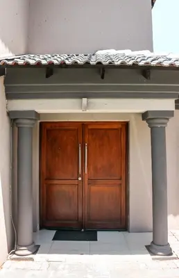 a wooden door in a building with two columns at Modern Home in Pretoria near Menlyn Mall in Pretoria