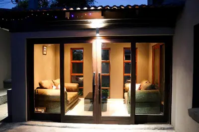 a glass door with two couches in a house at Modern Home in Pretoria near Menlyn Mall in Pretoria