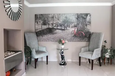 a living room with two chairs and a painting on the wall at Modern Home in Pretoria near Menlyn Mall in Pretoria