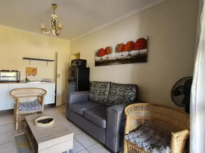 a living room with a couch and a kitchen at B&O's Place in Pretoria