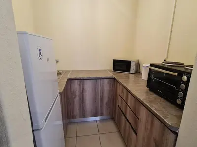 a kitchen with a white refrigerator and a microwave at B&O's Place in Pretoria